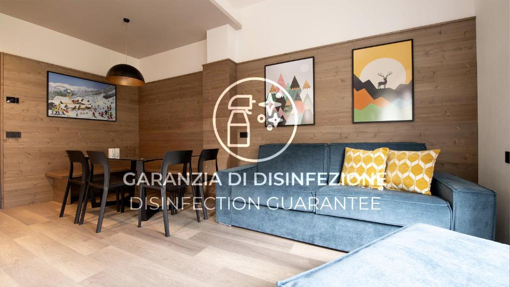 een woonkamer met een blauwe bank en een tafel bij Italianway - Roma 38 in Bormio