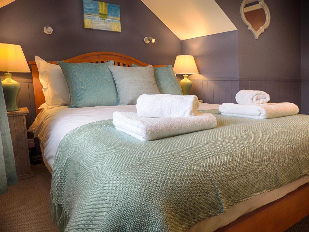 a bedroom with a bed with towels on it at The Lansdowne Cottage in Bourton on the Water