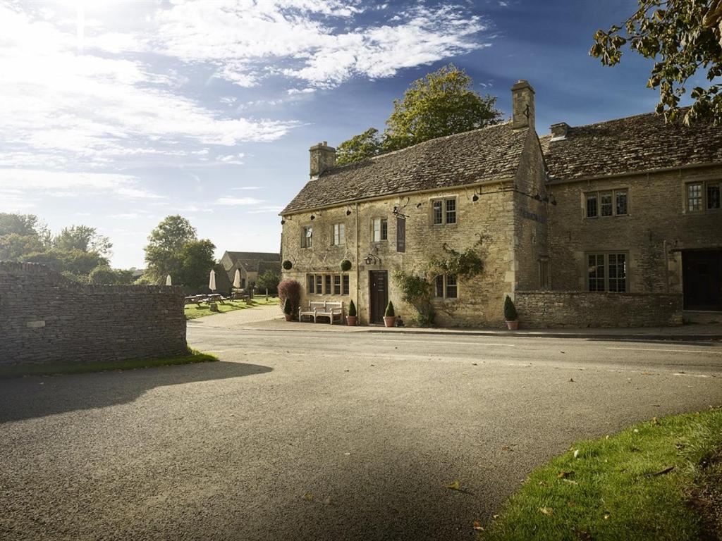 an old stone house sitting on a street at The Masons Arms in Cirencester