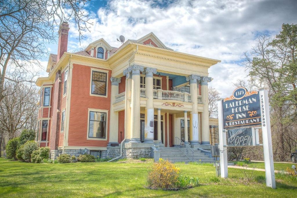 una casa grande con un cartel delante en Lauerman House Inn Bed & Breakfast, en Marinette