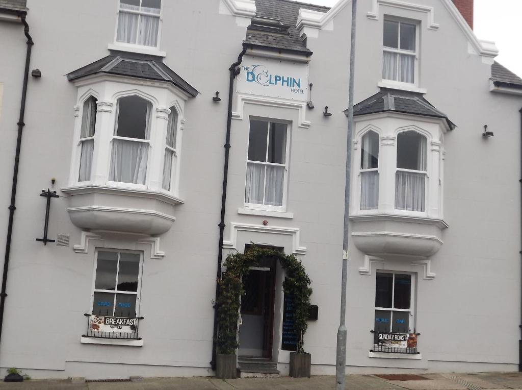 a white building with a sign on the front of it at The Dolphin Hotel in Pembroke Dock