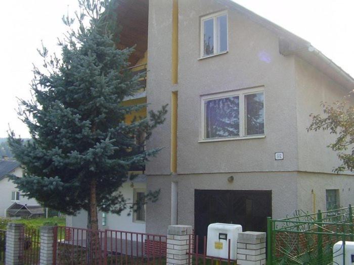 una casa con un pino delante de ella en Ubytovanie u Tomku, en Rejdová