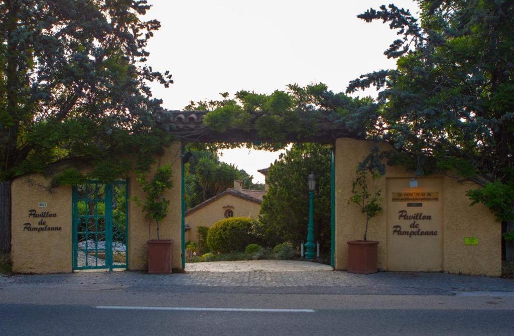 una entrada a un edificio con una puerta y árboles en Le Pavillon de Pampelonne en Saint-Tropez