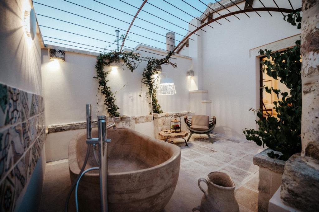 een badkamer met een groot bad in een kamer bij Pollicastro Boutique Hotel in Lecce