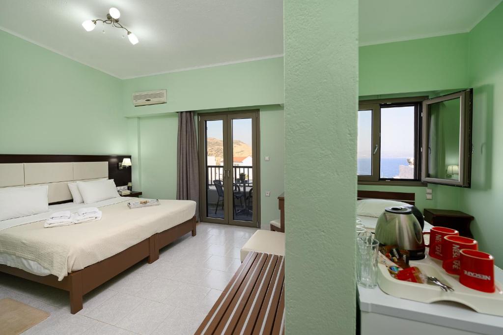 a hotel room with two beds and a mirror at Avra in Agia Galini