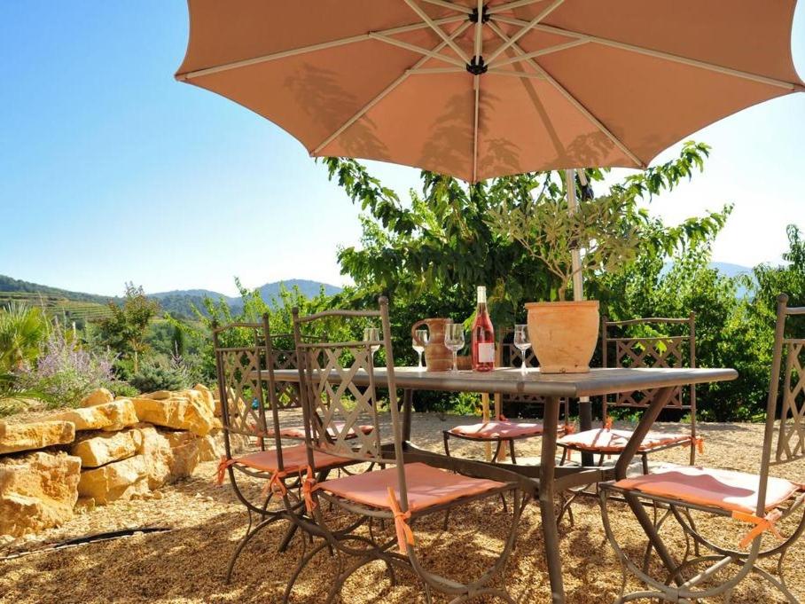 a table and chairs with an umbrella at Gite Les Aiguillans in Mérindol-les-Oliviers