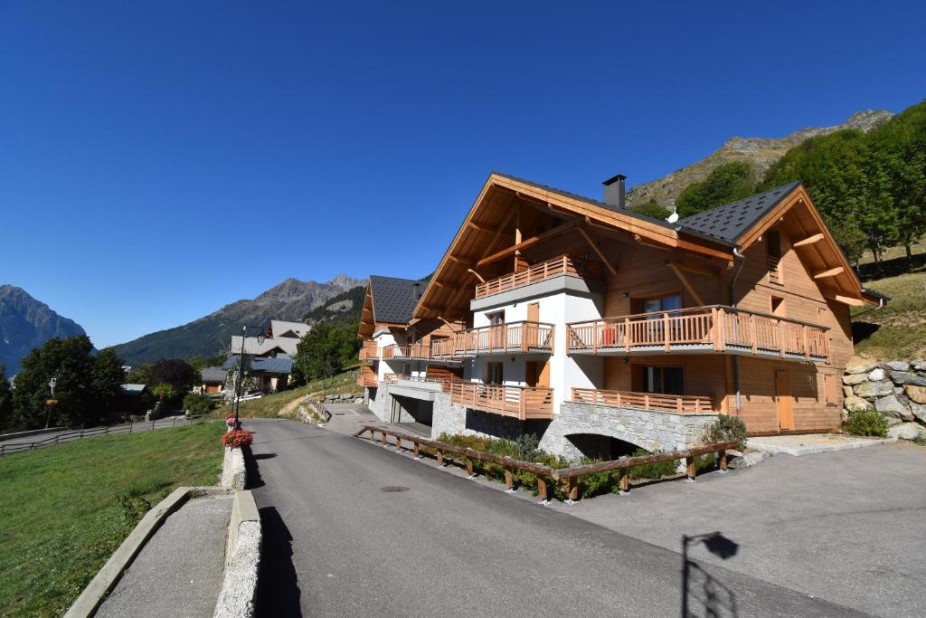a large wooden house on a mountain road at VAUJANYLOCATIONS - Ameythistes B8 in Vaujany