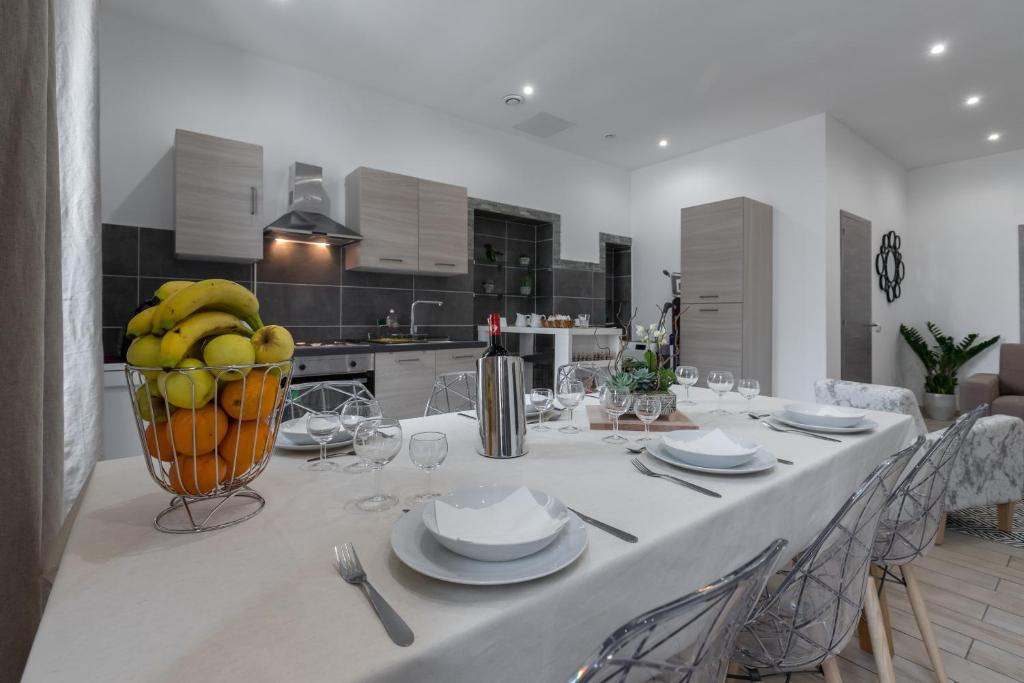 una mesa blanca con una cesta de plátanos en una cocina en Guest House Grimaldi, en Niza