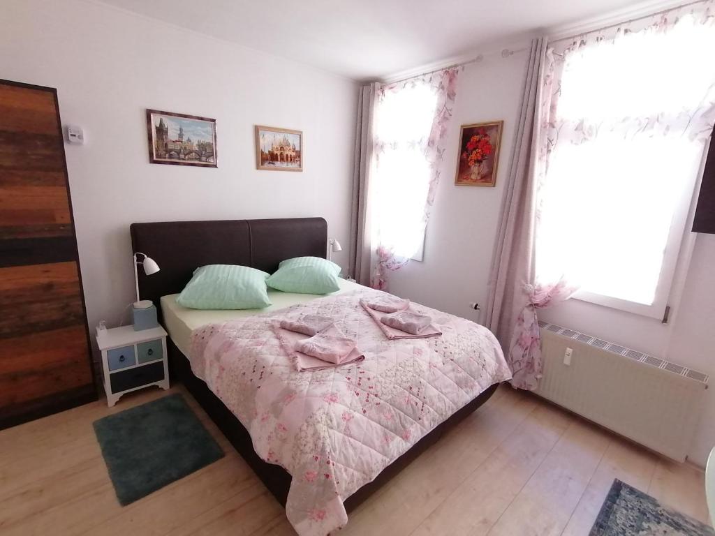 um quarto com uma cama com um cobertor rosa e 2 almofadas em Ferienwohnungen Burgfrieden 6 em Cochem