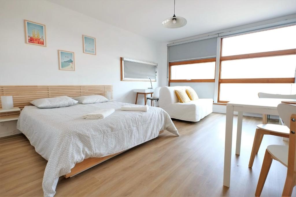 a white bedroom with a bed and a chair at Les Studiantes - T1 32 m² hypercentre gares/métro in Lille