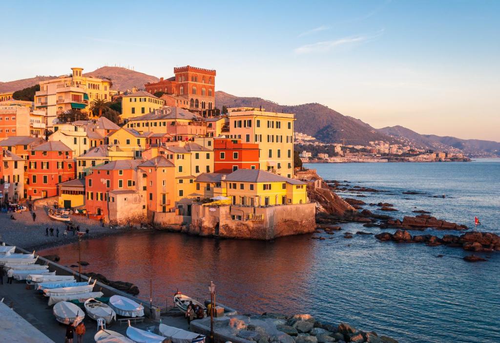 un groupe de bâtiments et de bateaux dans l'eau dans l'établissement Albergo Boccadasse, à Gênes