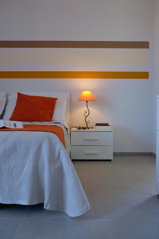 a bedroom with a bed and a lamp on a night stand at BNB Airone in Sommariva Perno
