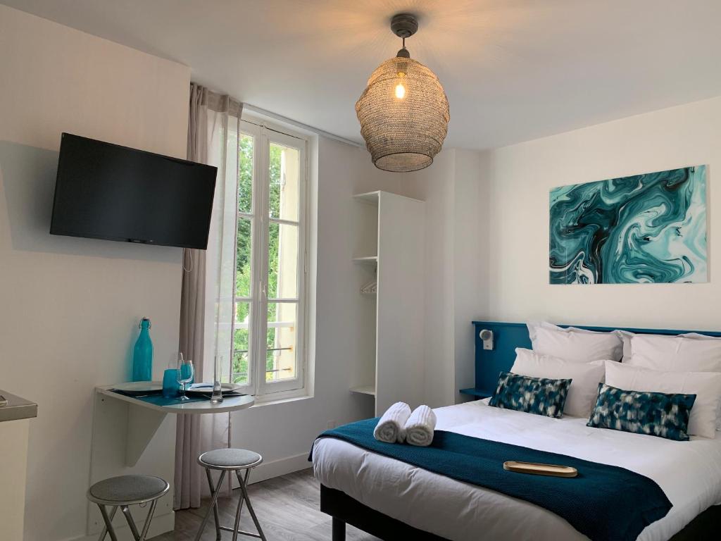- une chambre avec un grand lit et une fenêtre dans l'établissement Logis St Joseph, à Angers