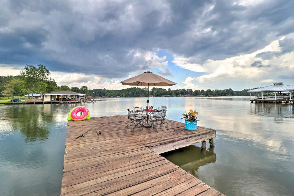 una mesa y sillas en un muelle con sombrilla en Eatonton Home with Dock and Lake Sinclair Views!, en Eatonton