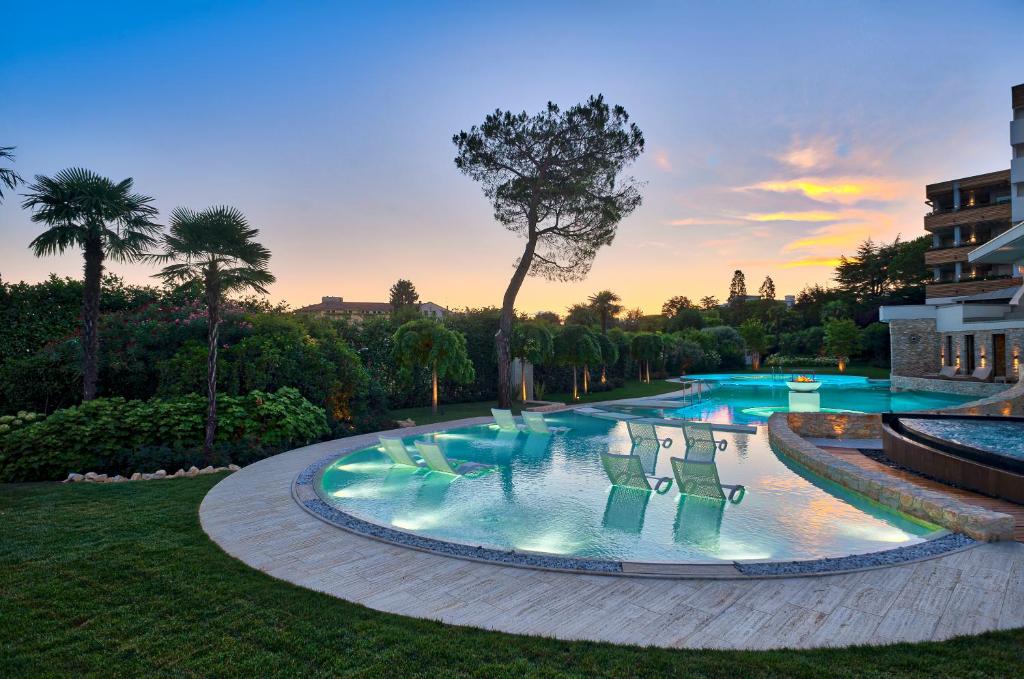 una gran piscina con sillas en un patio en Esplanade Tergesteo - Luxury Retreat en Montegrotto Terme