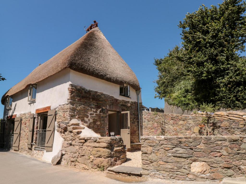 an old stone building with a thatched roof at The Old Cider Barn in Kingsbridge