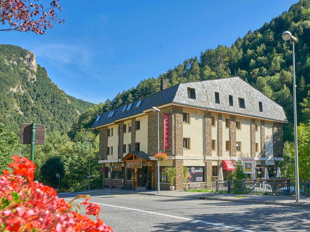 un grand bâtiment sur le côté d'une rue dans l'établissement Hotel Palarine, à Erts