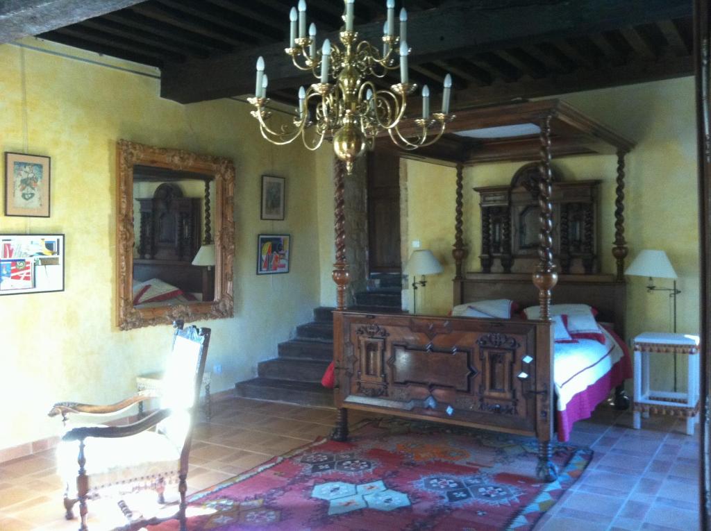 a bedroom with a bed and a chandelier at gite des rois ducs in Sauveterre-la-Lémance