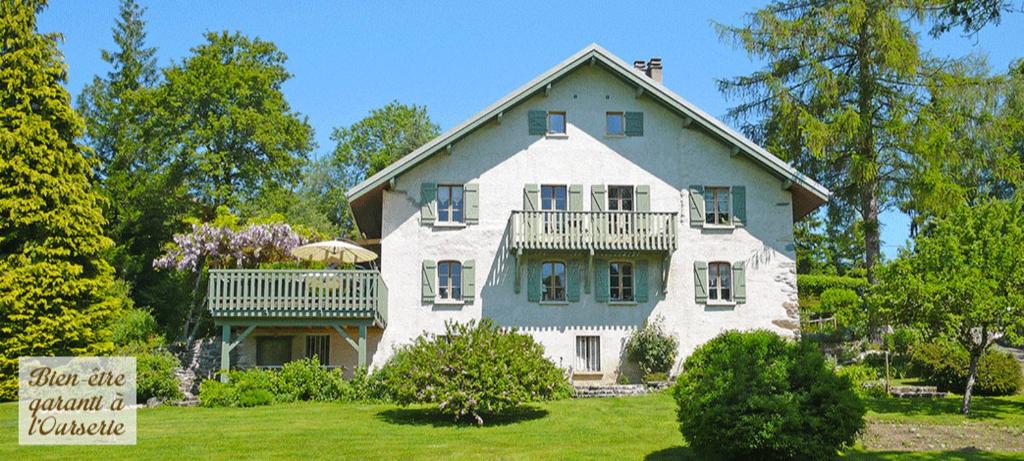 una gran casa blanca con un cartel delante en L'OURSERIE Bed & Breakfast, en Saint-Paul-en-Chablais