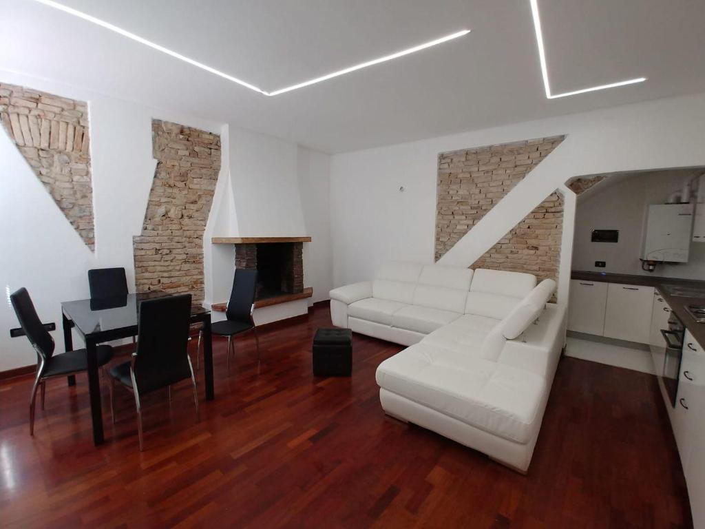 salon z białą kanapą i stołem w obiekcie APPARTAMENTO LAKE GARDA ibiscus di Francia w mieście Desenzano del Garda