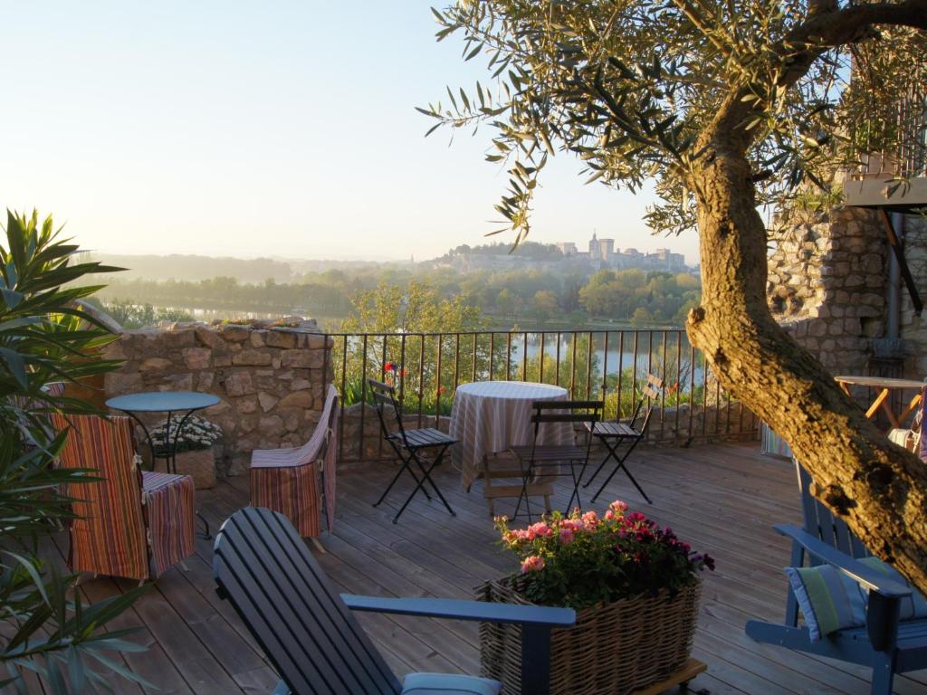 une terrasse avec des tables, des chaises et un arbre dans l'établissement Maison Orsini, à Villeneuve-lès-Avignon