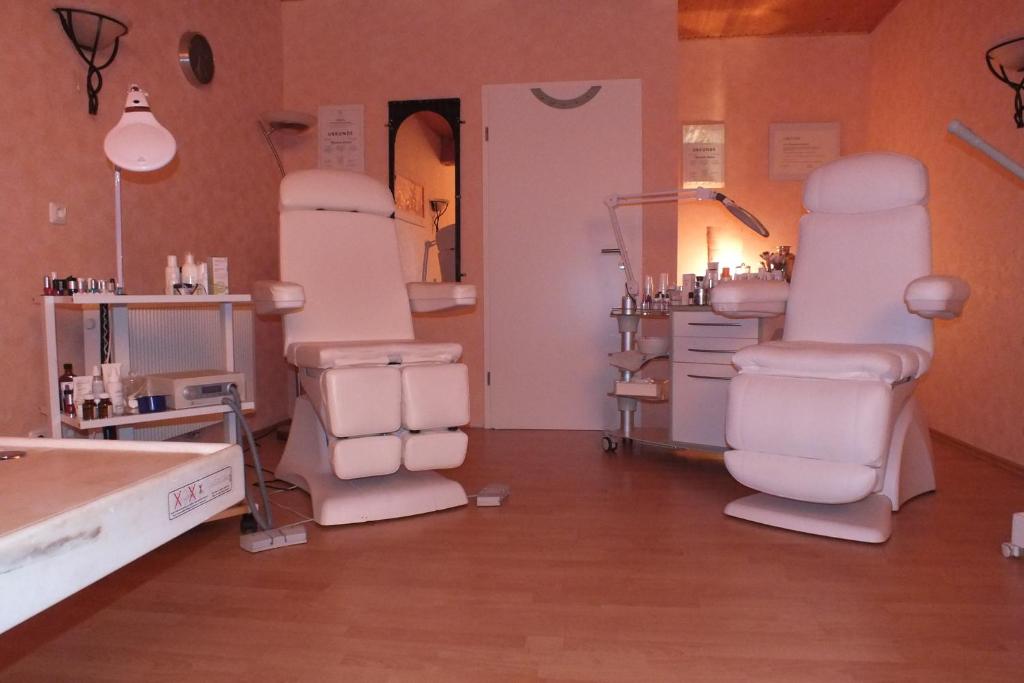a salon with white chairs in a room at Malus Ponyhof in Todenbüttel