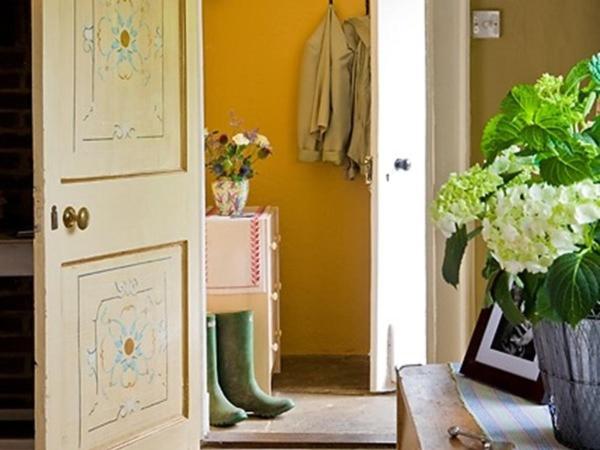 um corredor com uma porta com um vaso de flores e uma mesa em The Old Manor House B & B em Brasted