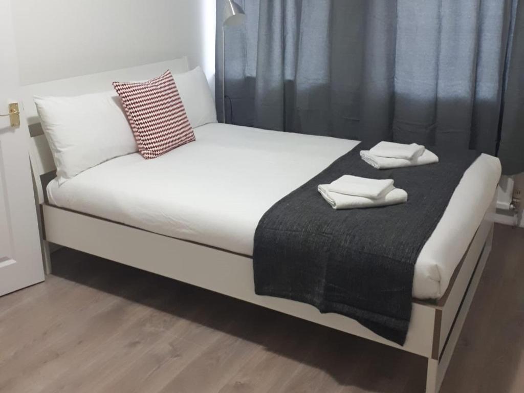 a bed with two towels on top of it at Marble Apartments Broadway Two in London