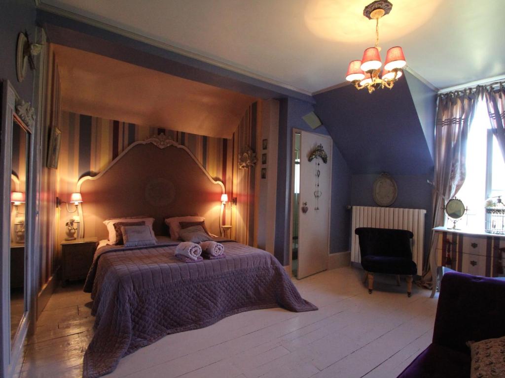 a bedroom with a large bed and a blue wall at La Mare Aux Bambous in Couffy