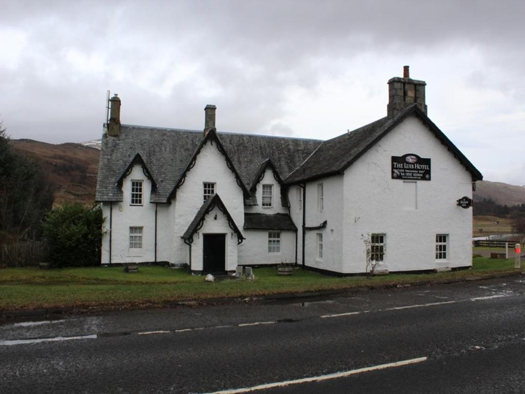 uma casa branca na berma de uma estrada em Luib Hotel em Killin