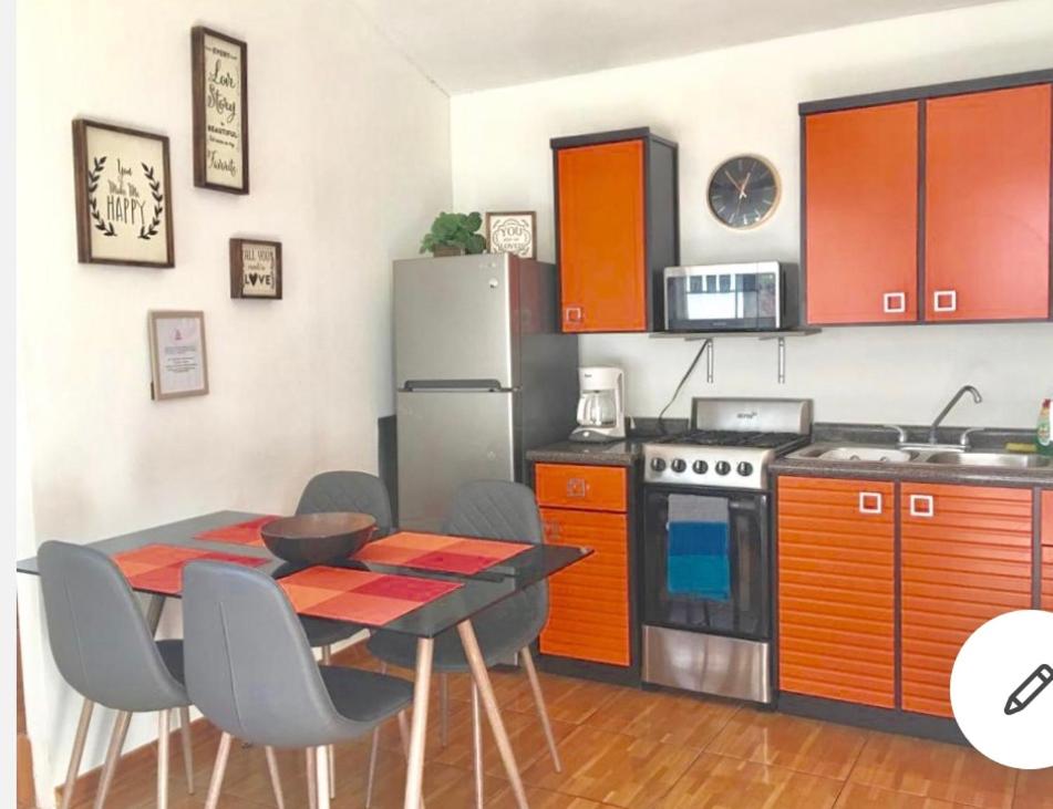 a kitchen with a table and a stove and a refrigerator at Agradable* y Cómodo Departamento Familiar (WiFi) in Chihuahua