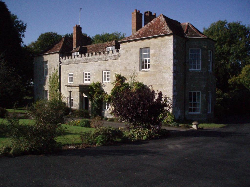 an old stone house with a roof at Marshwood Farm B&B and Shepherds Hut in Dinton