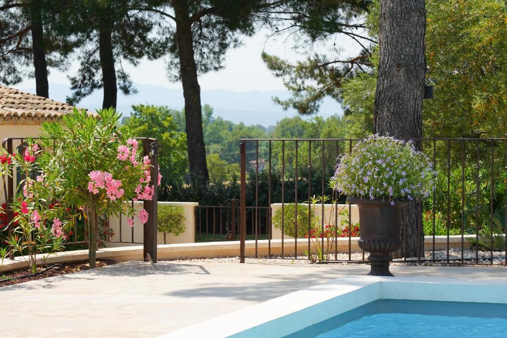 uma cerca de ferro com um vaso de planta ao lado de uma piscina em Cottage Aixois em Aix-en-Provence