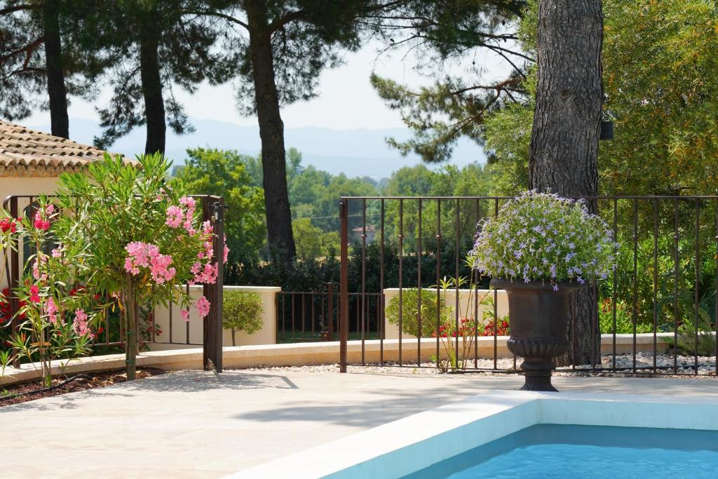 une clôture en fer avec une plante en pot à côté d'une piscine dans l'établissement Cottage Aixois Mas de la Granette, à Aix-en-Provence