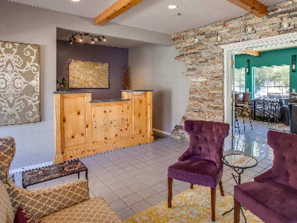 a living room with purple chairs and a stone wall at Leavenworth Village Inn in Leavenworth