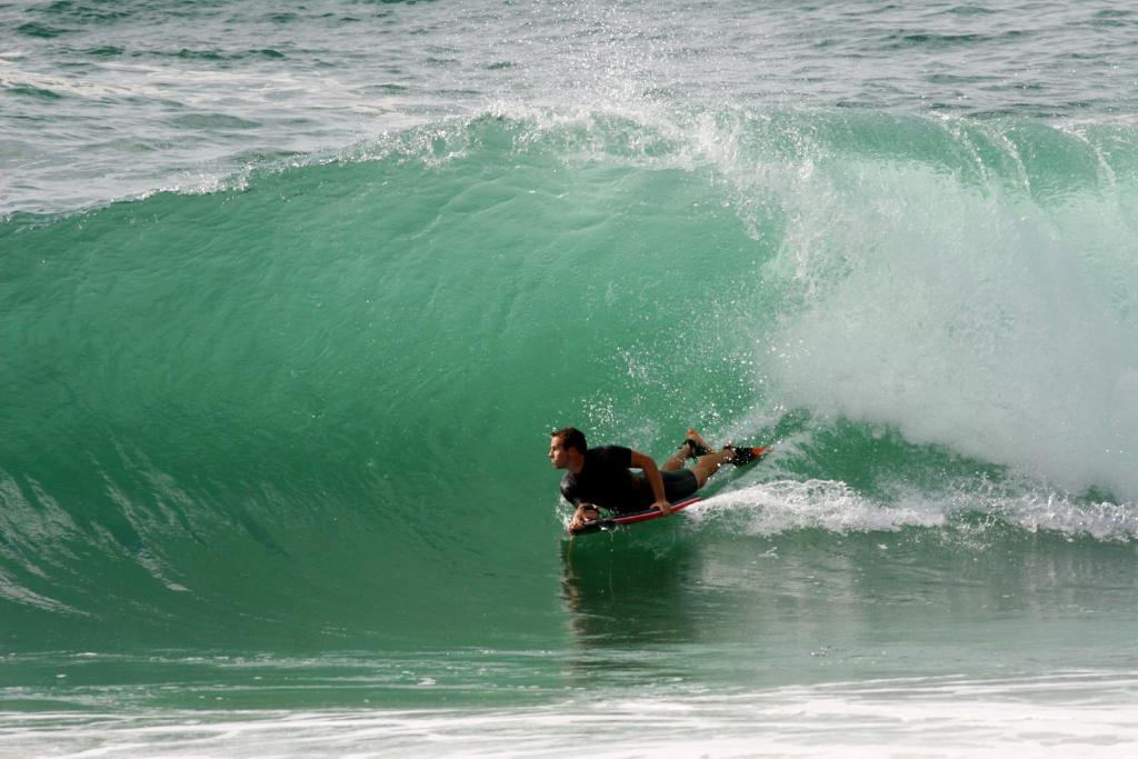 a man riding a wave on a surfboard in the ocean at Hotel Mare in Nazaré