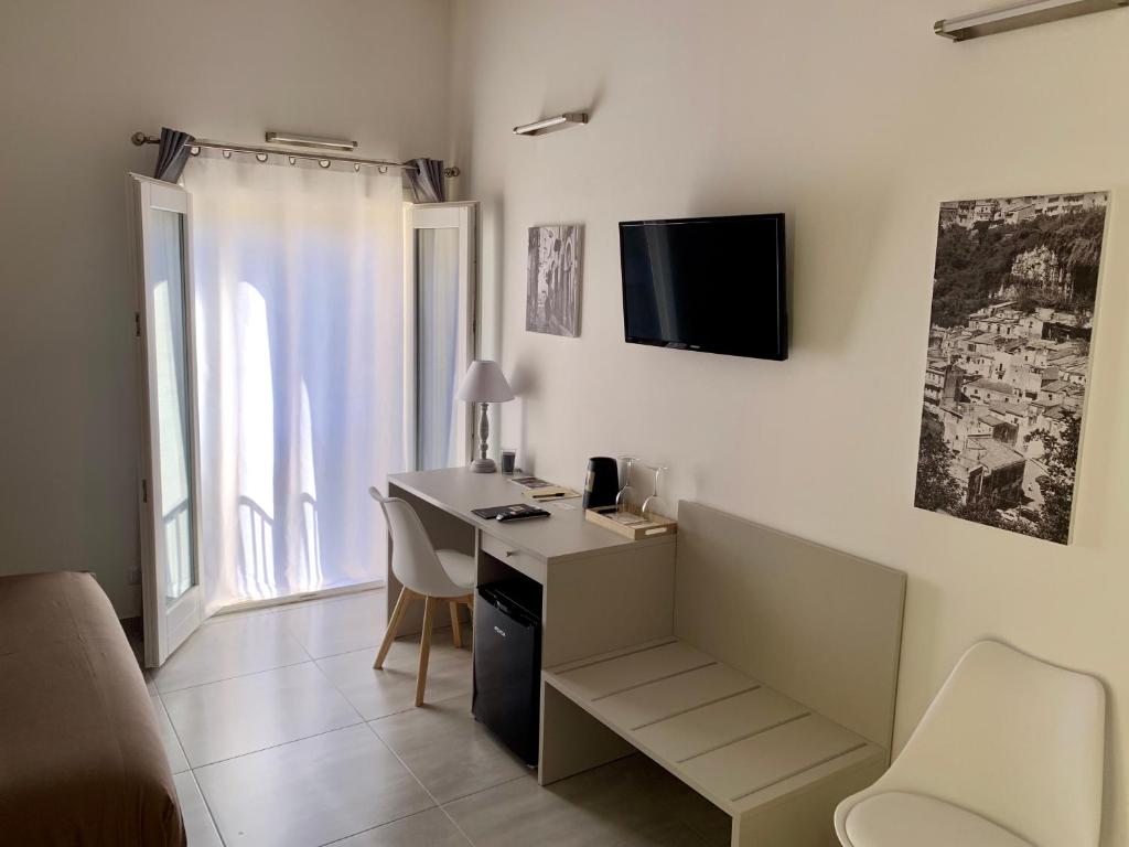 a room with a desk and a tv on the wall at Il Canale Design House in Ragusa