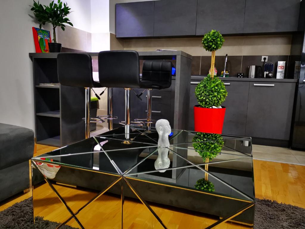 尼什的住宿－Merkur Luxury Apartman，玻璃桌,上面有两株盆栽植物