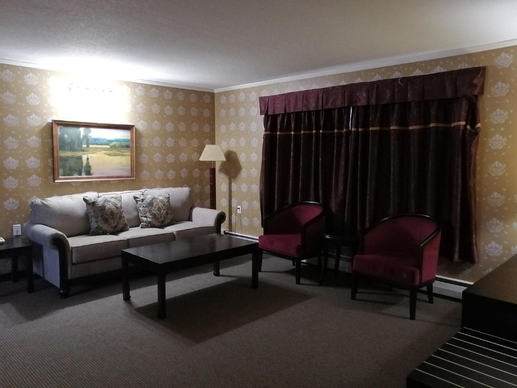 a living room with a couch and two chairs at Alpine Inn & Suites in Revelstoke