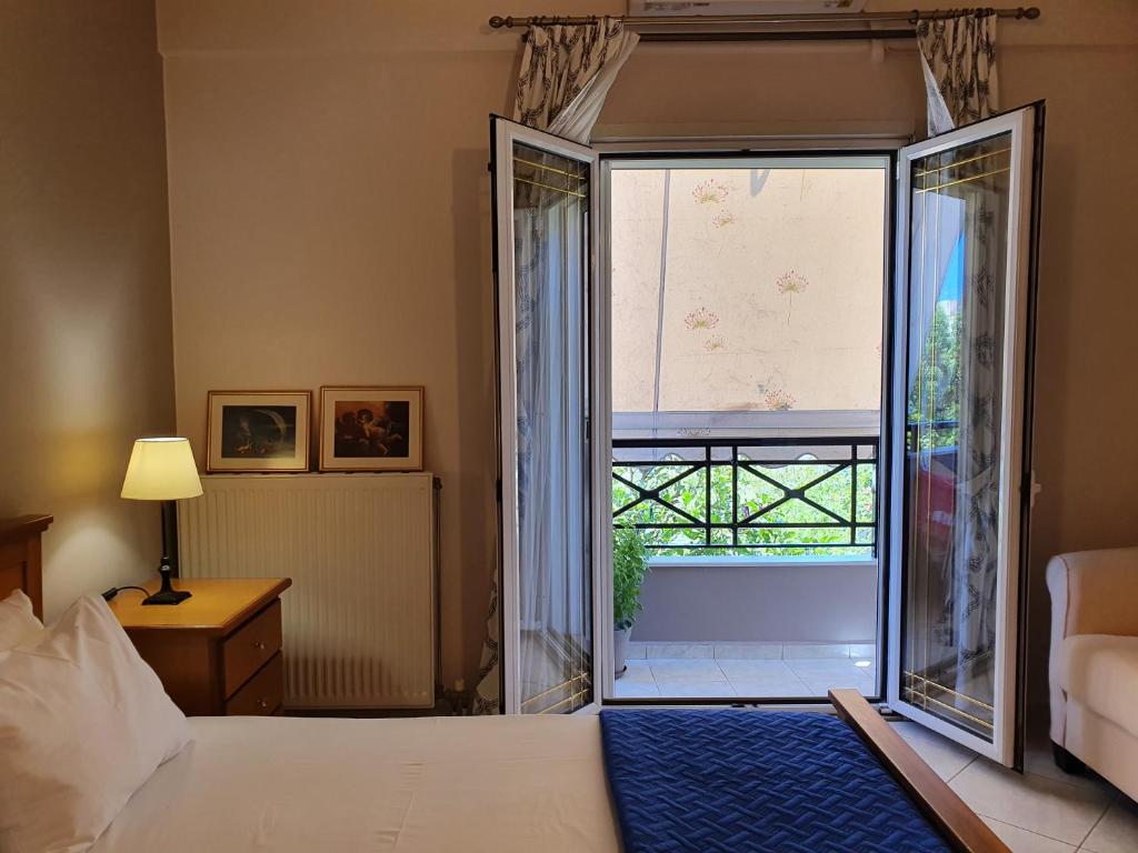 sypialnia z łóżkiem i dużym oknem w obiekcie Family Cozy Apartment w Heraklionie