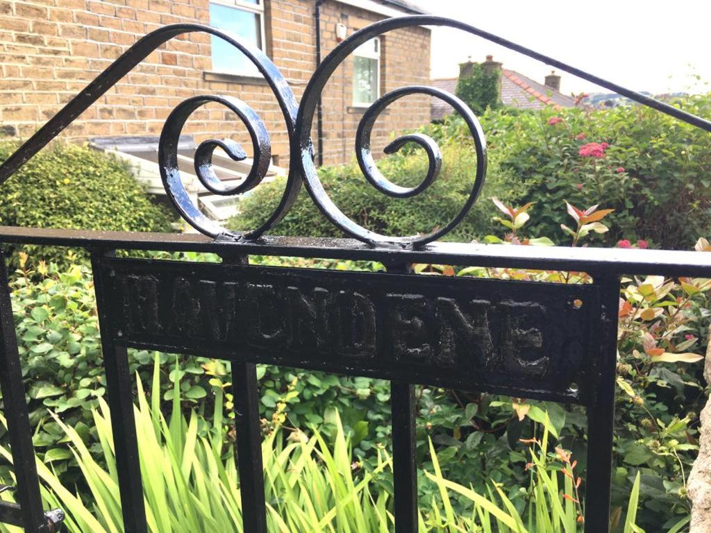 a wrought iron sign in front of a garden at Havendene in Haworth