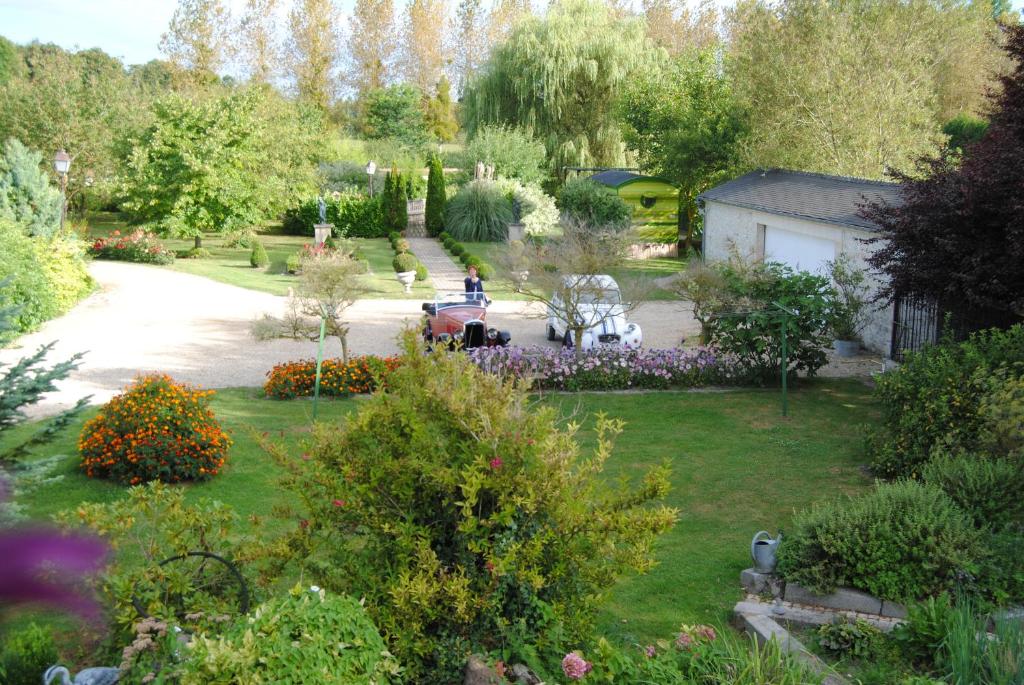 uma vista aérea de um jardim com flores e árvores em Les meublés du Grand Logis em Marchais