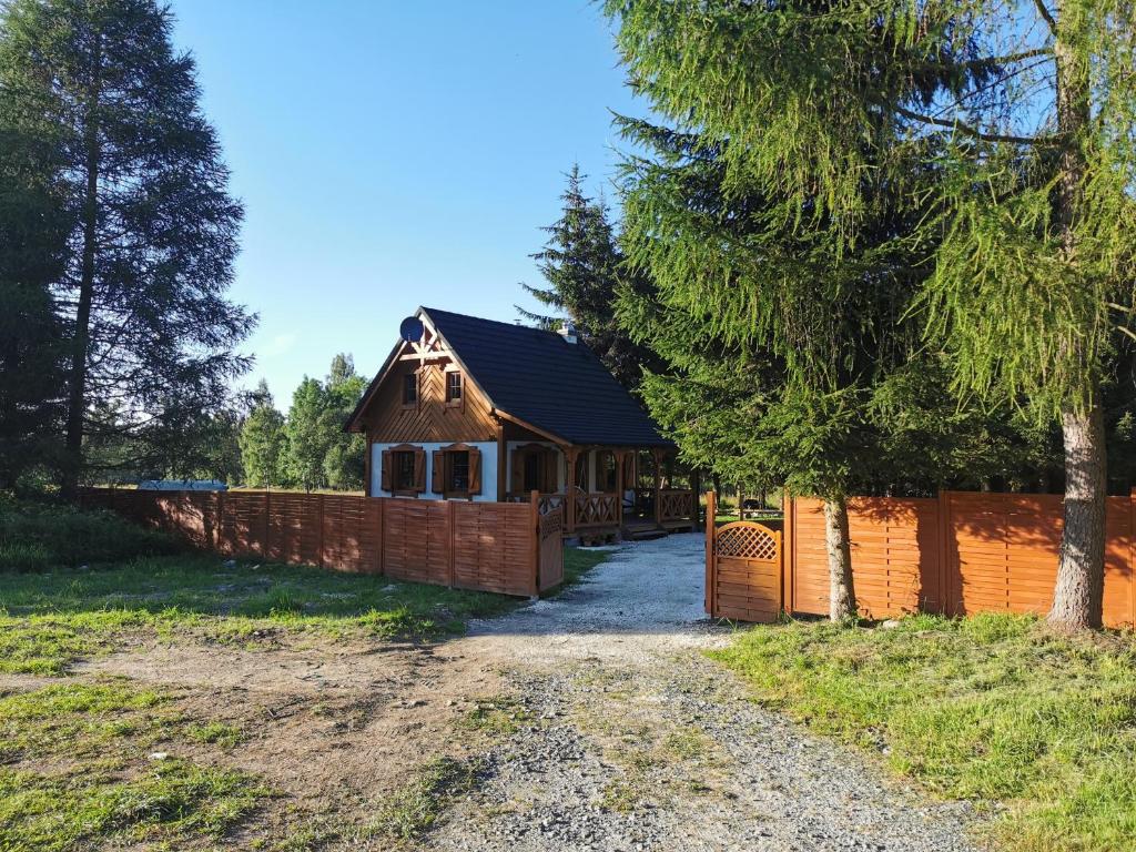 a house with a fence in front of it at Nad Potokiem z Alpakami in Stronie Śląskie
