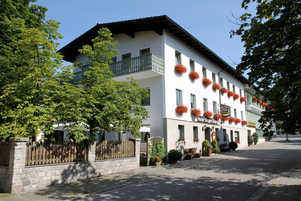 a white building with a balcony on a street at Landgasthof Fischer Veri in Mitterfels