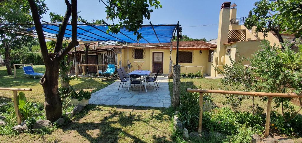 ein Haus mit einem Tisch und Stühlen im Hof in der Unterkunft Mikros Paradisos in Agria