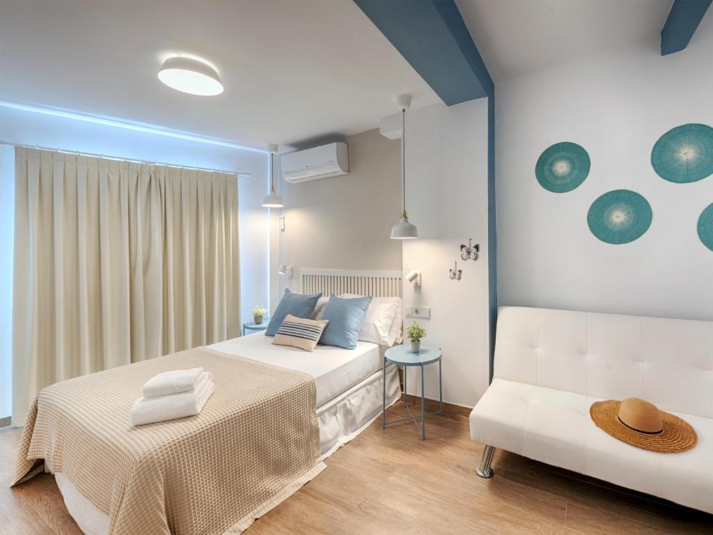 a bedroom with a white bed and a couch at Hostal Altea House in Altea