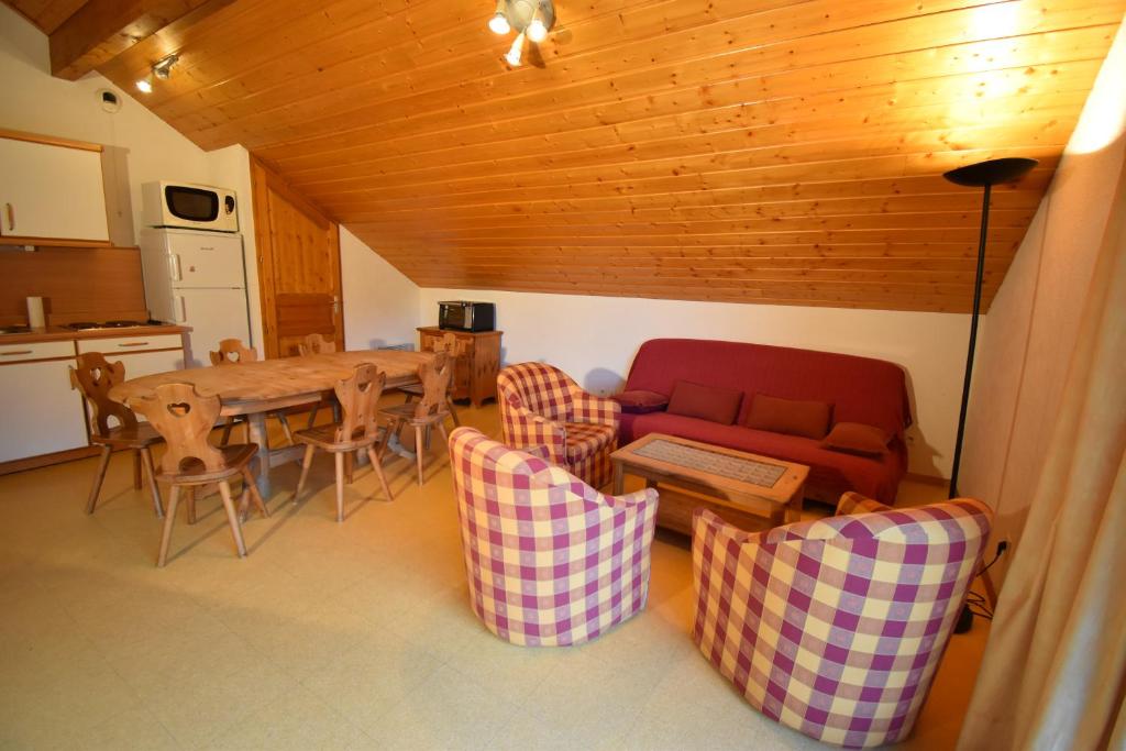 sala de estar con mesa, sofá y sillas en VAUJANYLOCATIONS - Les Balcons de Vaujany, en Vaujany