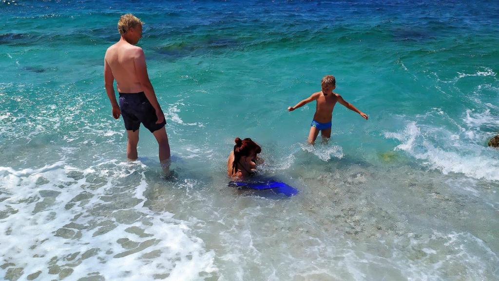 eine Gruppe von Menschen, die am Strand im Wasser spielen in der Unterkunft Apartment Ljubica in Šibenik