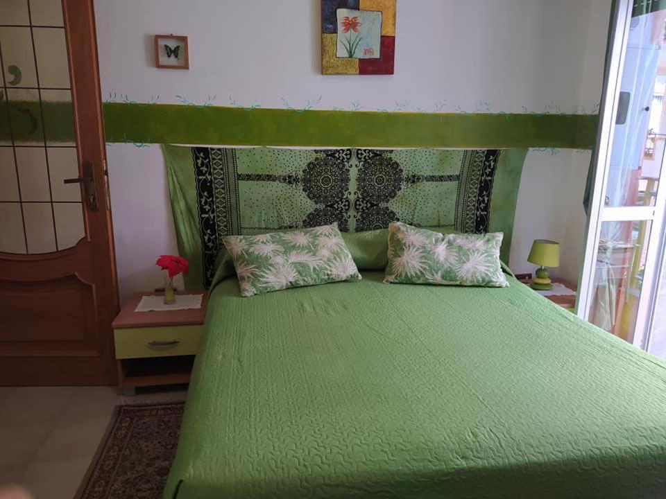 1 dormitorio con 1 cama verde y 2 almohadas en Lo Statere d' Argento, en Caulonia Marina