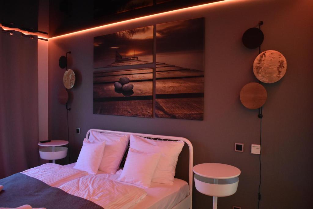 1 dormitorio con 1 cama con una pintura en la pared en Apartament Nadmorski, en Ustka